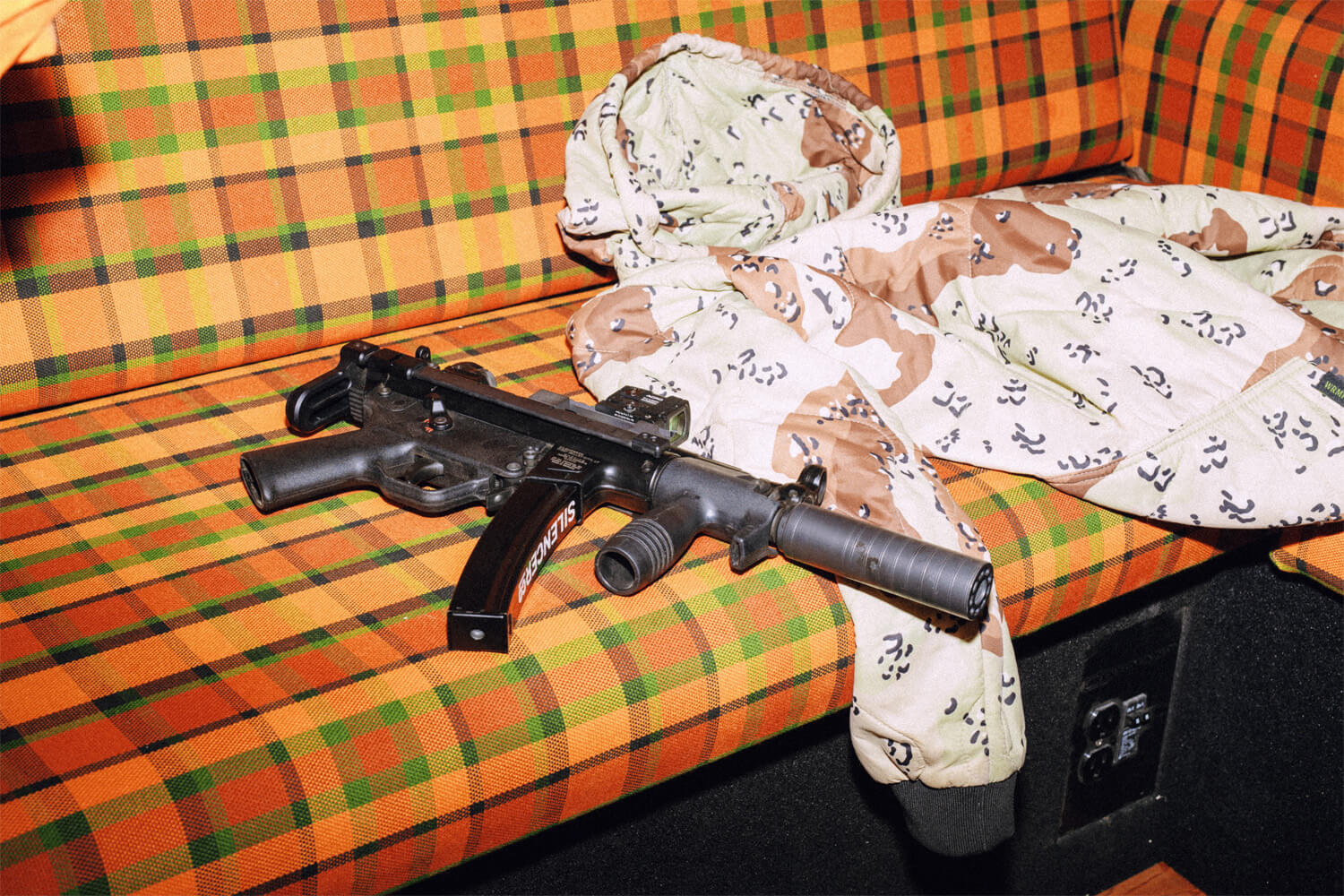 MP5 with SilencerCo Scythe-Ti and Chocolate Chip Camp hoodie on a vintage-style couch