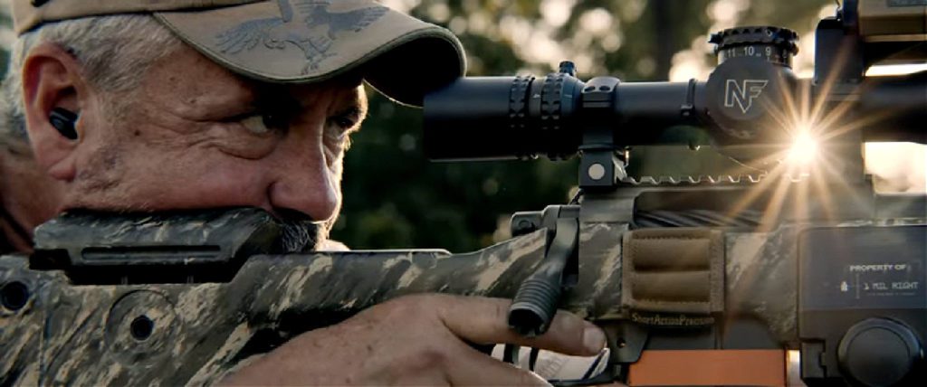 American Gun image of Riflesmith Terry Cross looking through scope on a rifle