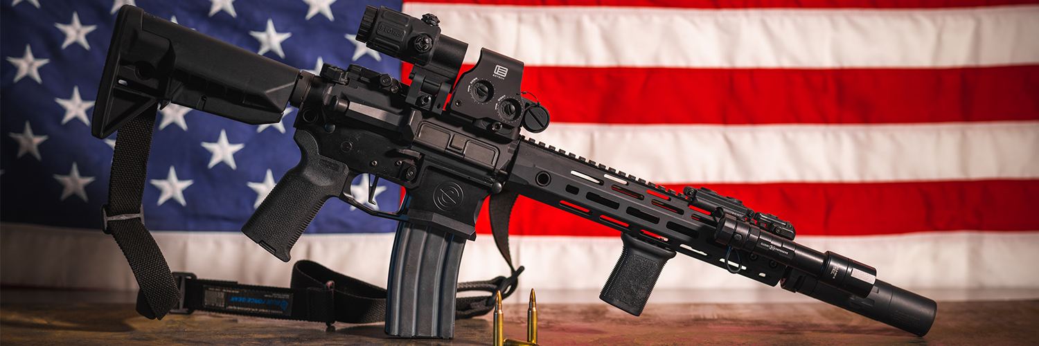 suppressed AR-15 in front of American Flag
