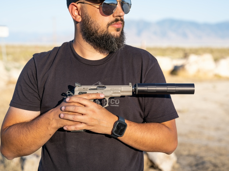 Man holding pistol with SilencerCo handgun suppressor