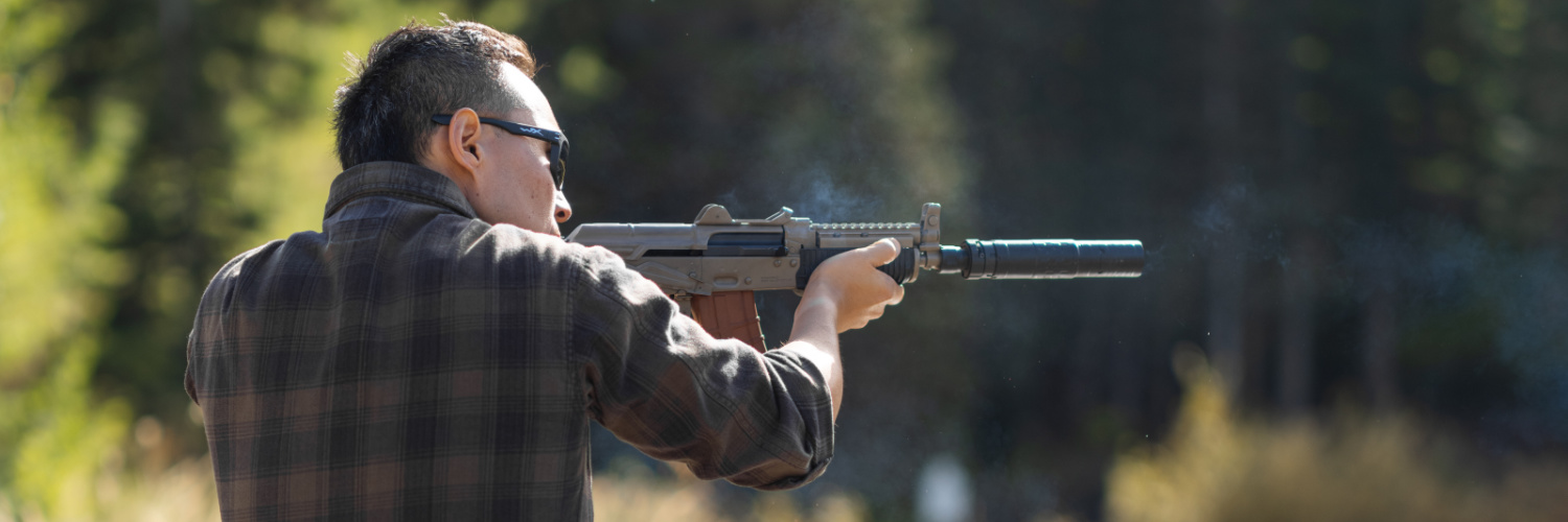 How do suppressors work? Man shooting suppressed rifle