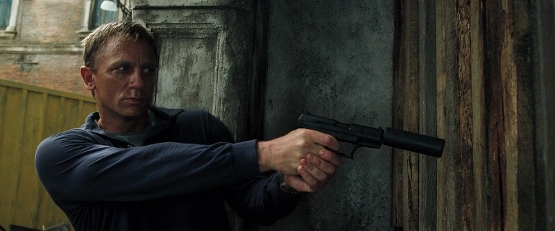 Daniel Craig as Agent 007 fires a Walther P99 with suppressor. Silencers in cinema