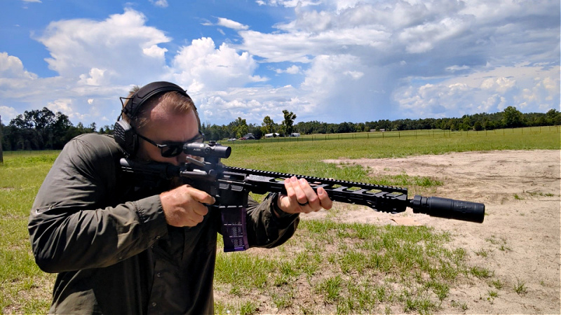 Man shooting rifle with Velos LBP 556K suppressor.