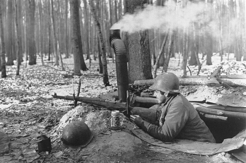 black and white photo of soldier aiming M-1 Garand from a trench