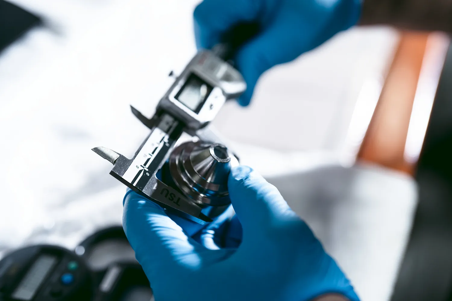 Silencerco, how suppressors are made: operator measures internall suppressor baffles with calipers before final silencer assembly.