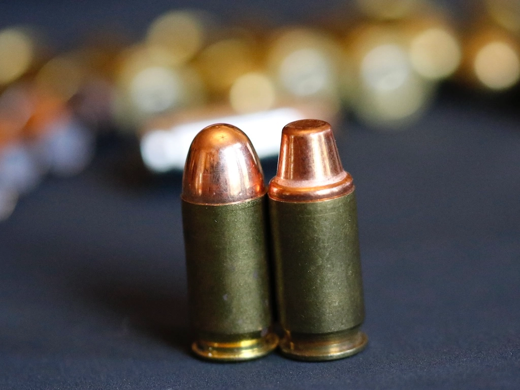 round nose and flat nosed 200 gr plated semi-wadcutter .45 ACP rounds side by side.