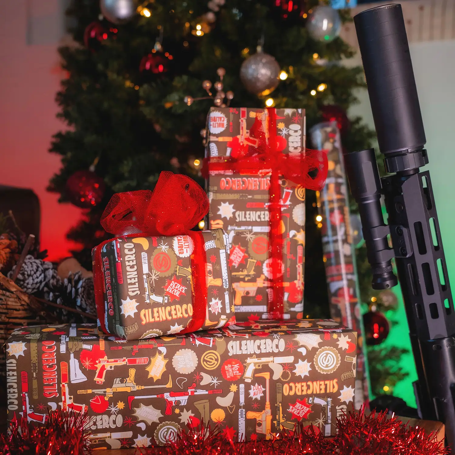 SilencerCo Wrapping Paper wrapped gifts with a gun under a tree.