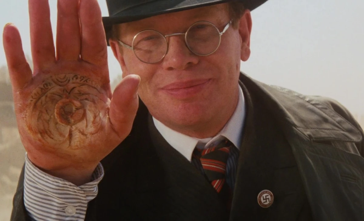 Major Arnold Toht from Spielberg's 1981 Raiders of the Lost Ark with emblem melted into palm of hand