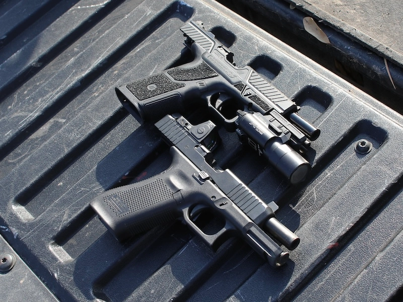 ZEV OZ9 and Glock handguns on tailbed
