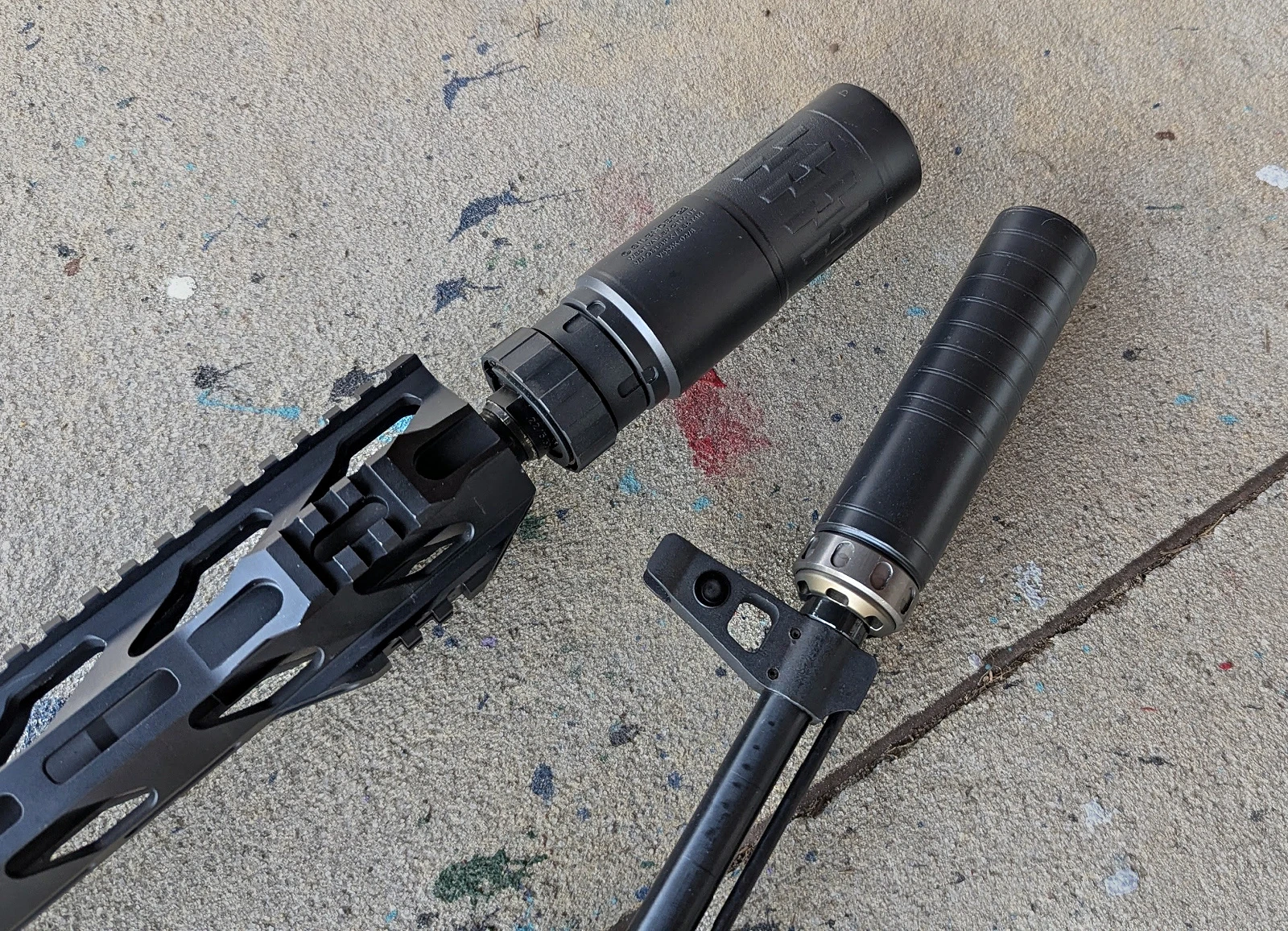 Two multi-caliber silencerco suppressors on rifles.