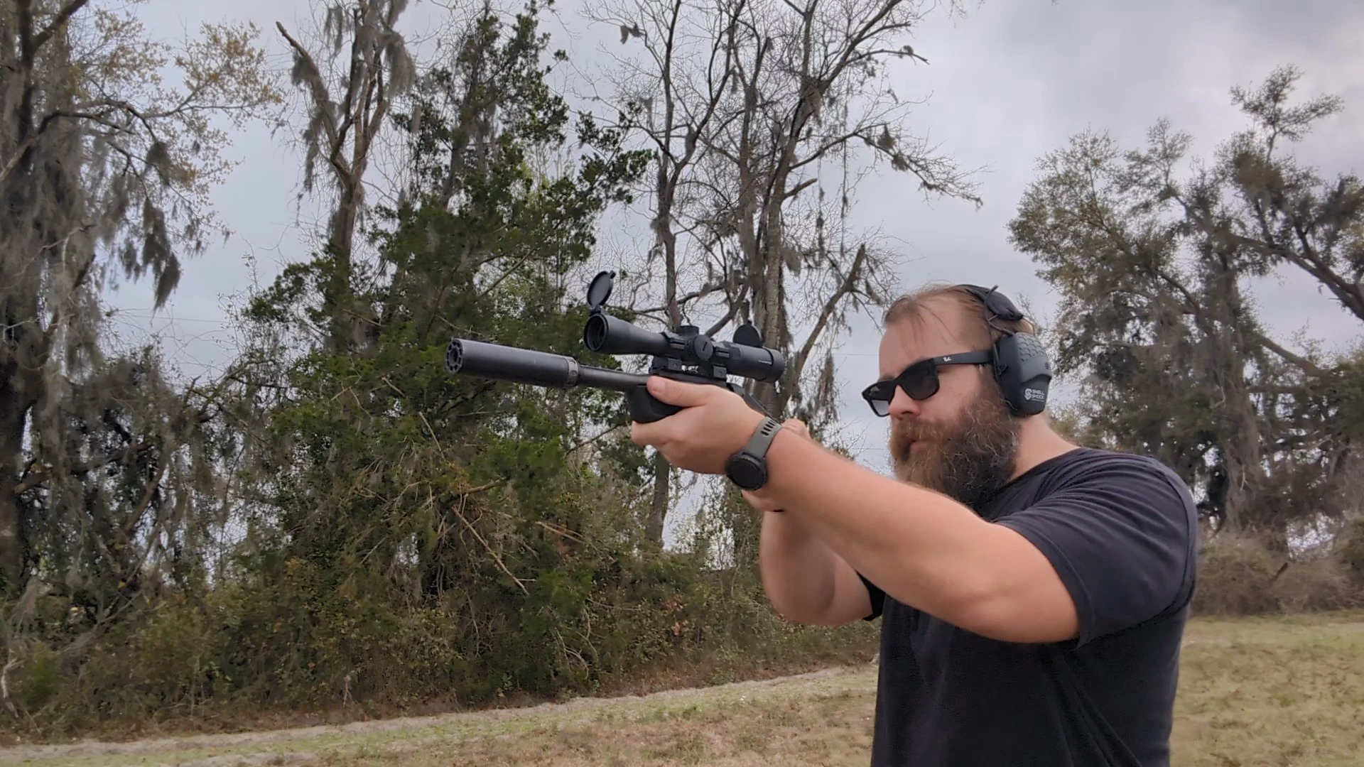man shooting a suppressed rifle-caliber pistol