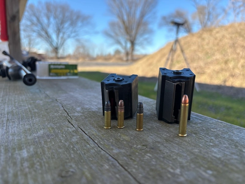 .22 LR cartridges in front of 10/22 rotary magazine, next to .22 Magnum cartridge in front of .22 Magnum rotary magazine