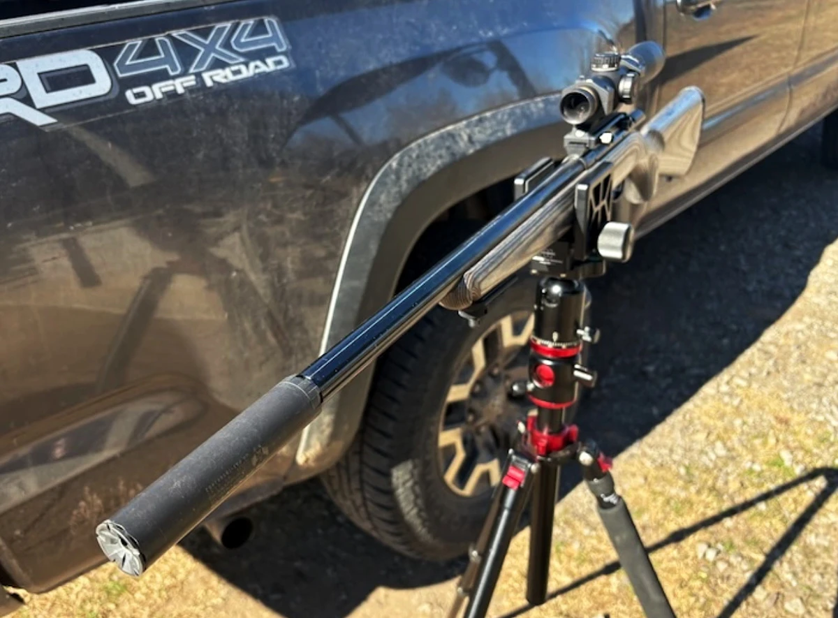 SilencerCo Sparrow on Ruger 22 WMR bolt action rifmire rifle beside truck