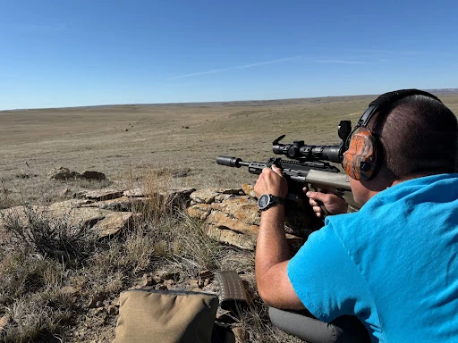 Man aims suppressed Steyr Aug downrange with Infitac thermal optic