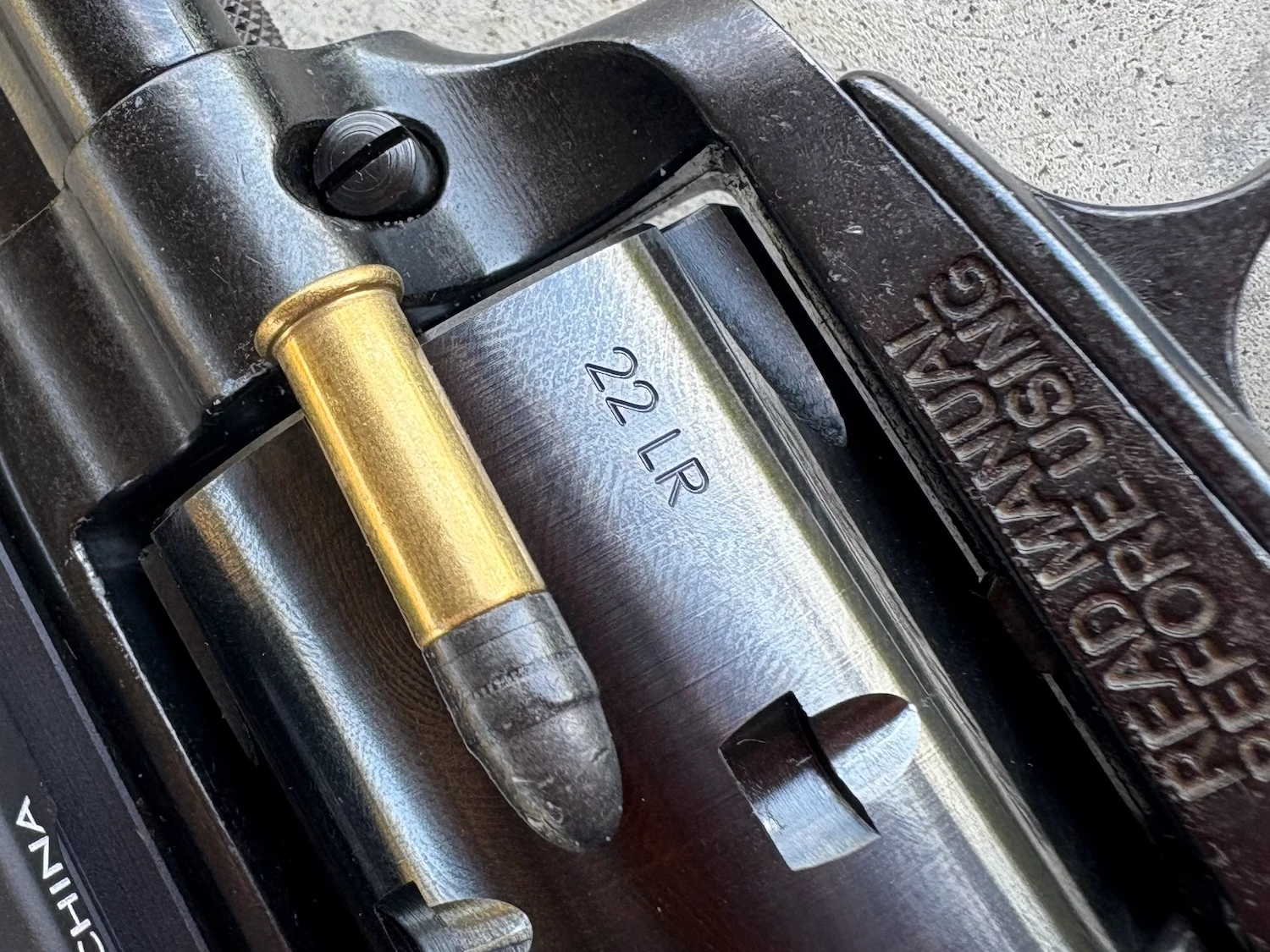 22LR cartridge next to Heritage Rough Rider Tactical Cowboy cylinder.
