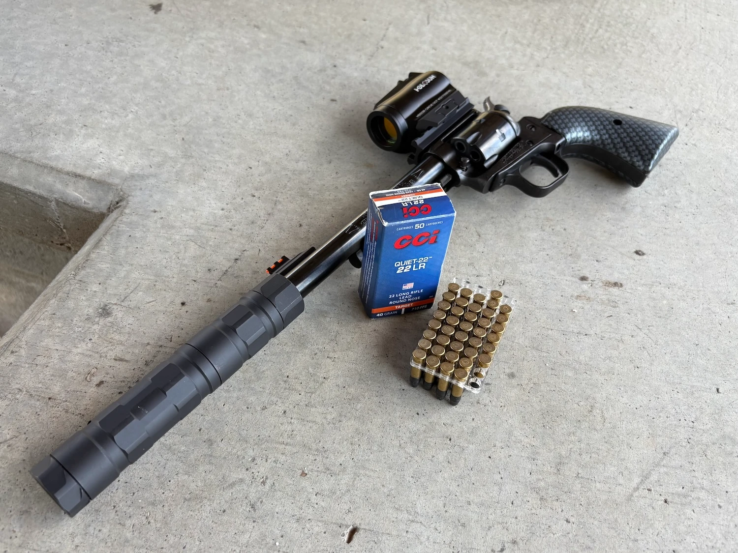 suppressed revolver with optic and a box of rimfire ammo